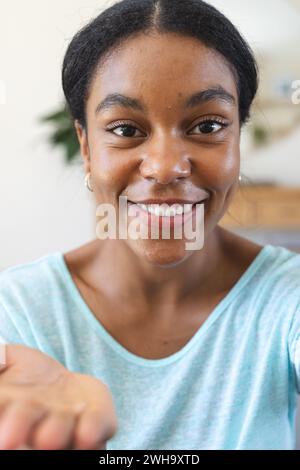 Eine junge Frau, die bei einem Videoanruf in die Kamera lächelt Stockfoto