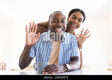 Fröhliches afroamerikanisches Paar genießt einen verspielten Moment zu Hause bei Videogesprächen Stockfoto