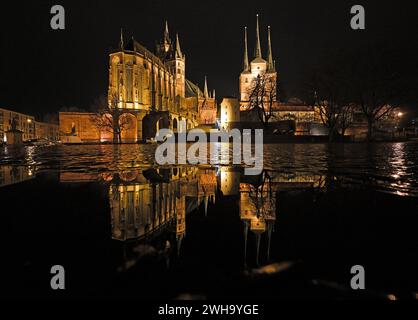 Erfurt, Deutschland. Februar 2024. St. Marienkathedrale und Severi-Kirche spiegeln sich auf dem regendurchfluteten Domplatz wider. Das Wetter bleibt tagsüber regnerisch und windig. Quelle: Martin Schutt/dpa/Alamy Live News Stockfoto