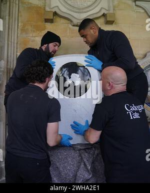 Die Arbeiter legten den Gedenkstein für Sir Ernest Shackleton im südlichen Kreuzgang der Westminster Abbey in London in der Nähe der Gedenkstätten für die Pioniere Captain James Cook, Sir Francis Chichester und Sir Francis Drake vor einer Einweihungszeremonie am 15. Februar an. Das Denkmal wurde vom Bildhauer will Davies geschaffen, der Steine wie grünen Connemara-Marmor und Kilkenny-Kalkstein einarbeitete, um Shackletons irisches Erbe zu widerspiegeln. Es ist mit den Namen von Shackletons Expeditionsschiffen und seinem Familienmotto Fortitudine vincimus (durch Ausdauer erobern wir) beschriftet. Bilddatum: Th Stockfoto