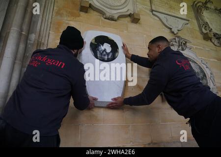 Die Arbeiter legten den Gedenkstein für Sir Ernest Shackleton im südlichen Kreuzgang der Westminster Abbey in London in der Nähe der Gedenkstätten für die Pioniere Captain James Cook, Sir Francis Chichester und Sir Francis Drake vor einer Einweihungszeremonie am 15. Februar an. Das Denkmal wurde vom Bildhauer will Davies geschaffen, der Steine wie grünen Connemara-Marmor und Kilkenny-Kalkstein einarbeitete, um Shackletons irisches Erbe zu widerspiegeln. Es ist mit den Namen von Shackletons Expeditionsschiffen und seinem Familienmotto Fortitudine vincimus (durch Ausdauer erobern wir) beschriftet. Bilddatum: Th Stockfoto