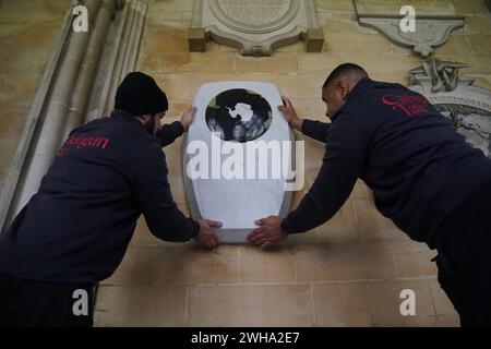 Die Arbeiter legten den Gedenkstein für Sir Ernest Shackleton im südlichen Kreuzgang der Westminster Abbey in London in der Nähe der Gedenkstätten für die Pioniere Captain James Cook, Sir Francis Chichester und Sir Francis Drake vor einer Einweihungszeremonie am 15. Februar an. Das Denkmal wurde vom Bildhauer will Davies geschaffen, der Steine wie grünen Connemara-Marmor und Kilkenny-Kalkstein einarbeitete, um Shackletons irisches Erbe zu widerspiegeln. Es ist mit den Namen von Shackletons Expeditionsschiffen und seinem Familienmotto Fortitudine vincimus (durch Ausdauer erobern wir) beschriftet. Bilddatum: Th Stockfoto