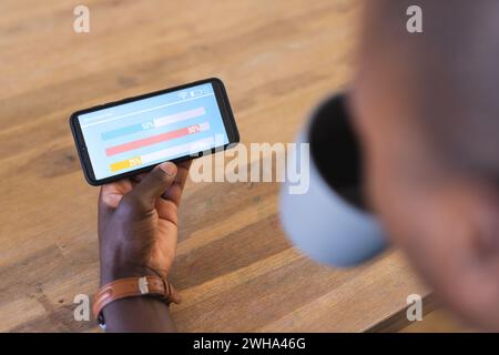 Junger afroamerikanischer Mann überprüft Smart-Home-App-Daten auf einem Tablet Stockfoto