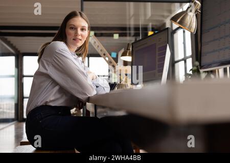 Junge kaukasische Frau posiert in einem modernen, zwanglosen Geschäftsbüro Stockfoto