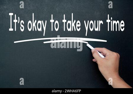 Es ist in Ordnung, sich Zeit zu nehmen, wenn man sich die Affirmation auf der schwarzen Tafel macht. Affirmation-Konzept. Stockfoto