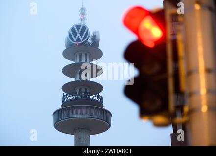 Hannover, Deutschland. Februar 2024. Eine rote Ampel leuchtet in Sichtweite des ehemaligen „Telemoritz“-Fernsehturms (auch bekannt als „VW-Turm“). Der 1959 erbaute und 141 Meter hohe Turm ist seit 2000 im Besitz von Volkswagen Nutzfahrzeugen. Medienberichten zufolge wird der Abriss des Turms in Erwägung gezogen. Quelle: Julian Stratenschulte/dpa/Alamy Live News Stockfoto