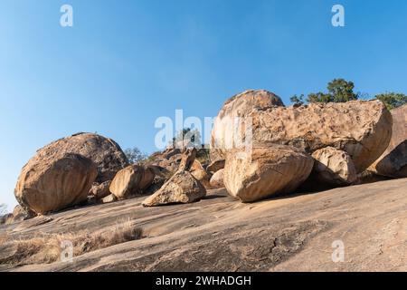 Dieses Bild fängt die ruhige Schönheit großer Granitblöcke ein, die vor einem klaren Himmel auf einem sanften Hang in Shravanabelagola liegen und die Natur reflektieren Stockfoto