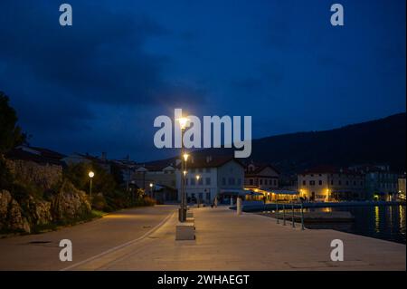 Cres, Kroatien - 24. Oktober 2022: Der Hafen von Cres in der Nacht, Straßenlaternen, blauer Himmel Stockfoto