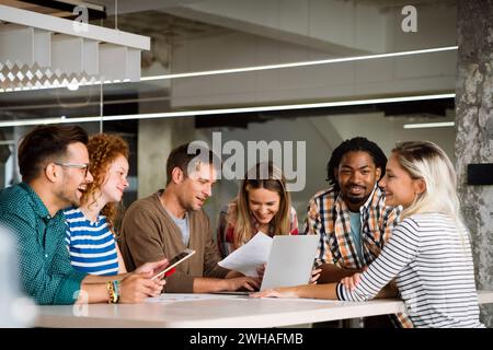 Verschiedene Kollegen aus dem Geschäftsbereich versammeln sich in einem Brainstorming, um Finanzstatistiken gemeinsam zu besprechen Stockfoto
