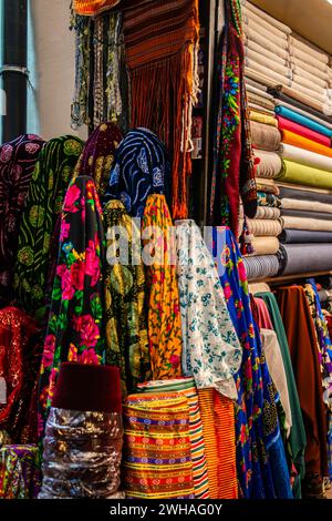 Traditionelle türkische Kleidung auf dem Basar, eine lebendige Ausstellung kultureller Textilien, Muster und Kleidungsstücke, die einen Markt mit verschiedenen Texturen schaffen Stockfoto