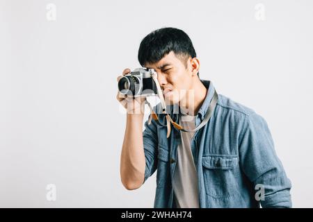 Eine alte Kamera klickt, während ein junger Mann nach einem Fotografen lächelt Stockfoto