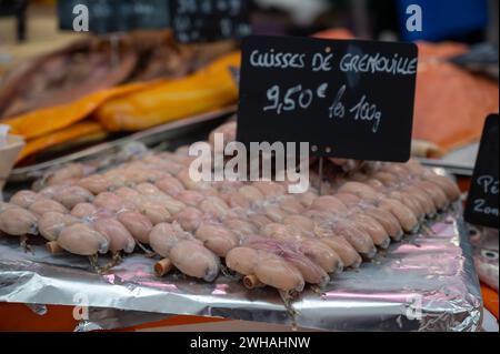 Fleischsortiment auf dem Wochenmarkt in Frankreich, englische Übersetzung: Froschschenkel, Preis von 100 gramm Stockfoto