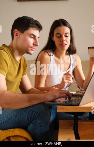 Spanisches Paar, das beim Frühstück den Laptop benutzt. Stockfoto