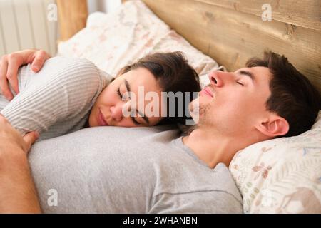Ein spanisches Paar schläft morgens auf dem Bett. Stockfoto