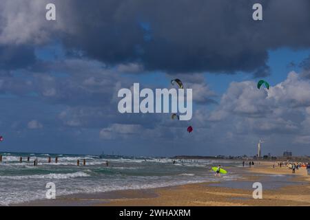 Wassersportbegeisterte mit verschiedenen Formen des Surfens und Segelns, fotografiert am Strand von Beit Yanai, Israel Beit Yanai ist ein Moshav im Zentrum von ISR Stockfoto