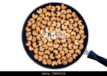 Cashew-Form Keks Namkeen Kaju Kekse Kekse Snacks in der Pfanne isoliert auf weißem Hintergrund Stockfoto