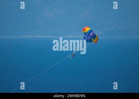 Gleitschirmfliegen für eine Person vom Boot am Beau vallon Beach, Mahe, Seychellen Stockfoto