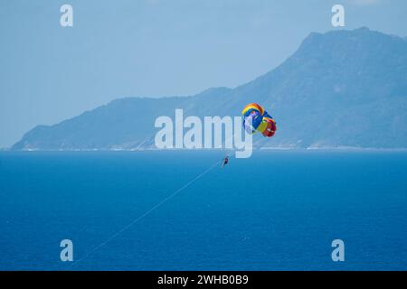 Gleitschirmfliegen für eine Person vom Boot am Beau vallon Beach, Mahe, Seychellen Stockfoto