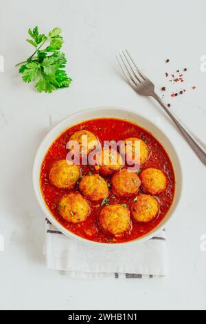 Hähnchenfleischbällchen mit scharfer Sauce aus Tomaten, garniert mit frischem Koriander Stockfoto