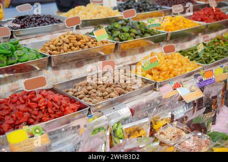 Lebendige und farbenfrohe Auswahl an getrockneten Früchten und Nüssen, die in Metallschalen auf einem Markt präsentiert werden und die Vielfalt und Attraktivität von gesunden Snack Optio unterstreichen Stockfoto