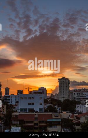 Farbenfrohe Sonnenuntergangswolken über den Wohngebäuden im Zentrum von Santo Domingo, Dominikanische Repbulic. Stockfoto