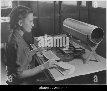 USA ca. 1950. Frau, die den Kartenpuncher bedient. Ein Card Puncher, ein integraler Bestandteil des Tabulationssystems, das vom United States Census Bureau verwendet wird, um Tausende von Fakten zu sammeln, die vom Bureau gesammelt wurden. Löcher werden in die Karte nach einem vorab vereinbarten Code eingestanzt, der die Fakten aus dem Erhebungsfragebogen in die Statistik überträgt." Stockfoto