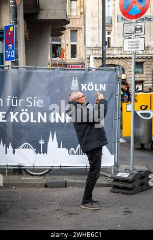 Mann steht vor einem Bauzaun und macht mit seinem Smartphone ein Foto vom Kölner Dom, Köln. ###NUR REDAKTIONELLE VERWENDUNG### Stockfoto