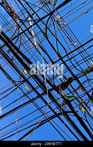 Elektrische Leitungen kreuzen sich und blauer Himmel in Ribeirao Preto, Sao Paulo, Brasilien Stockfoto