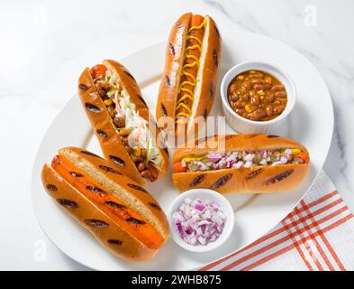 Karottenhunde mit veganem Chili, roten Zwiebeln, Senf, Slaw; pflanzliches Futterkonzept; Fleischalternative; Kopierraum Stockfoto