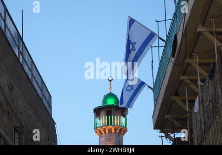 Israelische Fahnen winken vor dem Minarett einer Moschee in der Al-Wad Street im muslimischen Viertel der Altstadt von Jerusalem. Israel Stockfoto