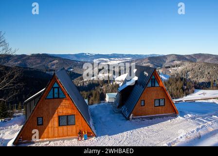 Zwei gemütliche Häuser mit Schnee, eingebettet am Fuße majestätischer Berge Stockfoto