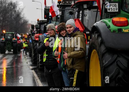 Posen, Polen, 9. Februar 2024. Bauern aus der Region Großpolen in Westpolen stehen vor ihren Traktoren, während sie die Aleja Niepodleglosci Straße im Zentrum von Poznań, der Hauptstadt Großpolens, vor dem Marschallamt der Regionen während des bundesweiten Bauernstreiks blockieren. Der Protest in Polen ist Teil des Protests der europäischen Landwirte gegen die EU-Verordnungen über den Grünen Deal. Die polnischen Landwirte fordern auch eine Änderung des EU-Abkommens mit der Ukraine über die Einfuhr landwirtschaftlicher Erzeugnisse in die EU. Der Protest in Poznań, der Hauptstadt von Großpolen, wurde von organisiert Stockfoto