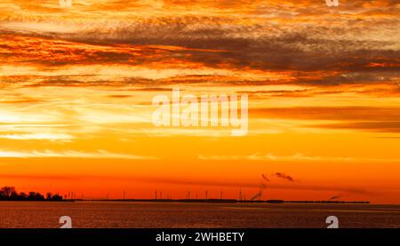 Windturbinen unter einem orangen Himmel Sonnenuntergang im Winter auf Amherst Island, Ontario, Kanada Stockfoto