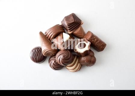 Sortiment mit einem Stapel von Zartbitterschokolade- und Milchschokoladenbonbons isoliert auf weißem Tisch. Draufsicht. Stockfoto