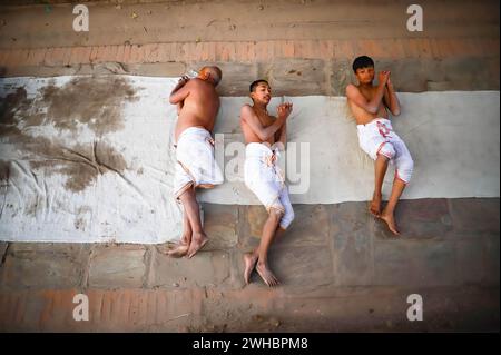 Bhaktapur, Nepal. Februar 2024. Hinduistische Gläubige beten, indem sie während eines einmonatigen Swasthani Brata Katha Festivals in Bhaktapur auf dem Boden krabbeln. Das monatelange Festival, das Gott Madhavnarayan und Göttin Swasthani gewidmet ist, beinhaltet die Rezitation von Volksgeschichten über wundersame Meisterleistungen, die von ihnen in vielen Hinduhaushalten durchgeführt werden. Quelle: SOPA Images Limited/Alamy Live News Stockfoto