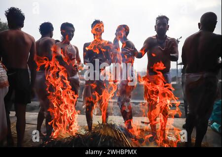 Bhaktapur, Nepal. Februar 2024. Hindugeweihte erwärmen sich nahe dem Feuer, nachdem sie während des Swasthani Brata Katha Festivals in Bhaktapur Gebete an den Hanuman Ghat River geopfert hatten. Das monatelange Festival, das Gott Madhavnarayan und Göttin Swasthani gewidmet ist, beinhaltet die Rezitation von Volksgeschichten über wundersame Meisterleistungen, die von ihnen in vielen Hinduhaushalten durchgeführt werden. Quelle: SOPA Images Limited/Alamy Live News Stockfoto