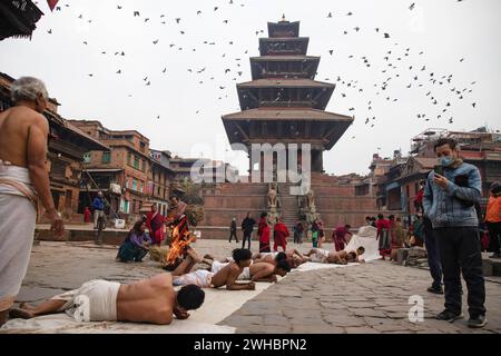 Bhaktapur, Nepal. Februar 2024. Hinduistische Gläubige beten, indem sie während eines einmonatigen Swasthani Brata Katha Festivals in Bhaktapur auf dem Boden krabbeln. Das monatelange Festival, das Gott Madhavnarayan und Göttin Swasthani gewidmet ist, beinhaltet die Rezitation von Volksgeschichten über wundersame Meisterleistungen, die von ihnen in vielen Hinduhaushalten durchgeführt werden. Quelle: SOPA Images Limited/Alamy Live News Stockfoto