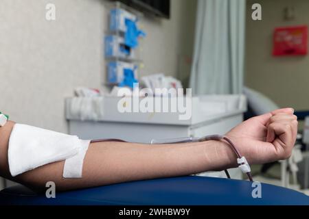 Eine Person in Handschuhen, die Eine Nadel auf Eine Schaufensterpuppe legt. Stockfoto