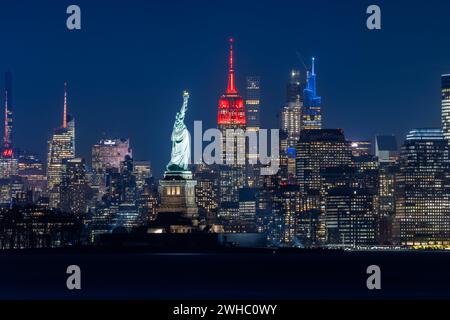 New York, USA. Februar 2024. Dieses am 8. Februar 2024 aufgenommene Foto zeigt das Empire State Building, das zum chinesischen Neujahrsfest in New York rot beleuchtet wurde. Das Empire State Building begann seine Mondneujahrsfeier am Donnerstag mit einer zeremoniellen Beleuchtung und der Enthüllung der Fifth Avenue Window Exhibition. ZUM BEISPIEL „New York Empire State Building glänzt rot für das chinesische Neujahrsfest“ Guthaben: Winston Zhou/Xinhua/Alamy Live News Stockfoto