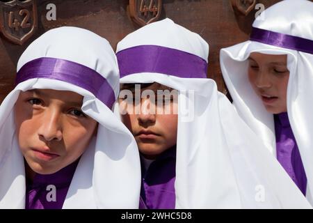 Antigua, Guatemala. Jugendliche Jungen, die während der Karwoche einen Schwimmer in einer religiösen Prozession tragen, La Semana Santa. Stockfoto