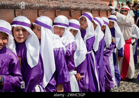 Antigua, Guatemala. Jugendliche Jungen, die während der Karwoche einen Schwimmer in einer religiösen Prozession tragen, La Semana Santa. Stockfoto