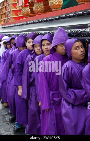 Antigua, Guatemala. Jugendliche Jungen, die während der Karwoche einen Schwimmer in einer religiösen Prozession tragen, La Semana Santa. Stockfoto