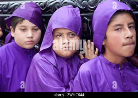 Antigua, Guatemala. Jugendliche Jungen, die während der Karwoche einen Schwimmer in einer religiösen Prozession tragen, La Semana Santa. Stockfoto