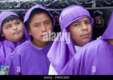 Antigua, Guatemala. Jugendliche Jungen, die während der Karwoche einen Schwimmer in einer religiösen Prozession tragen, La Semana Santa. Stockfoto