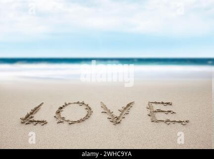 Schreiben Sie Liebe in Sand am Strand Stockfoto