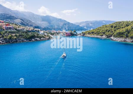 ASSOS malerisches Fischerdorf von oben, Kefalonia, Griechenland. Luftdrohnenansicht. Segelboote liegen in türkisfarbener Bucht. Stockfoto