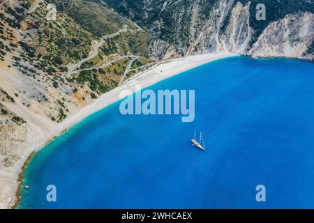 Blick aus der Vogelperspektive auf die luxuriöse Segelyacht am Strand von Myrtos mit blauer Bucht auf der Insel Kefalonia, Griechenland. Stockfoto