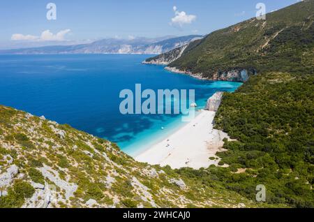 Atemberaubender Blick auf den Strand von Fteri mit weißem segelboot in verborgener Bucht, Kefalonia, Griechenland. Umgeben von mediterraner Vegetation. Trekkkingpfad. Erstaunliche Meeresumseen. Stockfoto