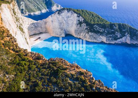 Luftaufnahme des Navagio Beach - Shipwreck Beach - auf der Insel Zakynthos, Griechenland. Touristen auf Klippe genießen die Aussicht auf Sommer Reise. Stockfoto