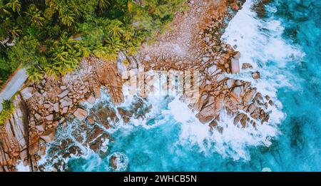 Luftdrohnen-Ansicht der tropischen Küste mit türkisfarbenen Ozeanwellen, die gegen bizarre Granitfelsen plätschern. Reisekonzept. Stockfoto